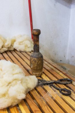 Kruje, Durres, Arnavutluk. 14 Ekim 2024. Çiğ yün geleneksel keçeye dönüştürülecek, bir pounder ve makasla..