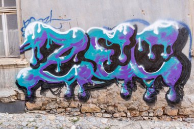 Ohri, Kuzey Makedonya. 21 Ekim 2024. Ohri 'nin eski bir kasabasında duvarda mor ve deniz mavisi grafitti.