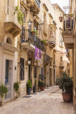 Malta, Birgu. Taş binaları olan dar bir sokak..