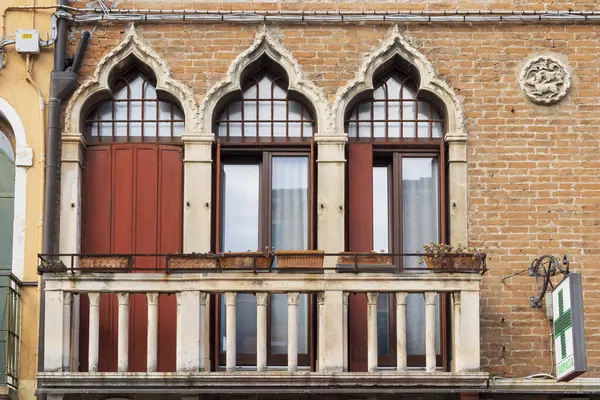 İtalya, Venedik. Castello bölgesi. Sağ üst köşesinde Gotik pencereler ve madalyon bulunan bina detayları.