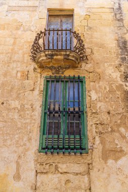 Malta, Mdina. Taştan bir duvarda dövülmüş demir muhafızları olan pencereler..
