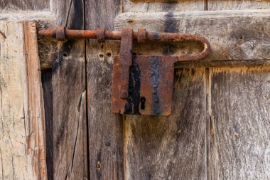 Yıpranmış ahşap bir kapının paslanmış antika kilidi. Scilla, İtalya.