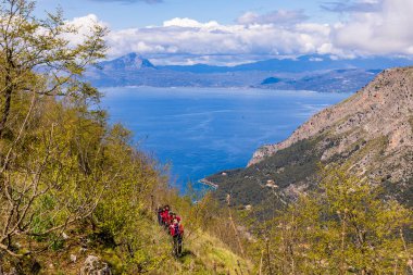 9 Nisan 2023. İtalya, Basilicata, Maratea. Monte San Biagio 'dan Maratea ve Tyrhenian Denizi' nin genel görünümü, Kurtarıcı İsa heykelinin yeri. Zirveye tırmanan yürüyüşçüler.