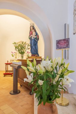 9 Nisan 2023. İtalya, Basilicata, Maratea. San Biagio 'nun tepesindeki Basilica di San Biagio. İç mekan. Paskalya zambakları ve Meryem ve İsa 'nın heykeli.