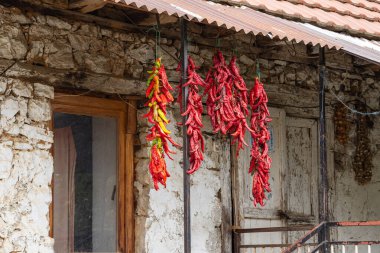 Kuratica, Ohri, Kuzey Makedonya. Kırmızı biber dizeleri kurumak için sallanıyor..