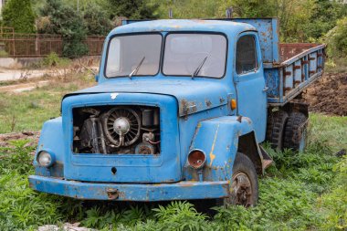Kuratica, Ohri, Kuzey Makedonya. Eski mavi bir çöp kamyonu tarlaya park etmiş..