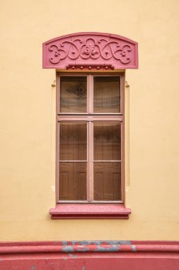 Sremski Karlovci, Backa Bölgesi, Voyvodina, Sırbistan. Sarı duvardaki kırmızı budanmış pencere.