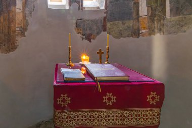 Veljusa, Strumica, Kuzey Makedonya. 3 Eylül 2024. Theotokos Manastırı 'ndaki kilisede üzerinde İncil ve mumlar olan bir masa..