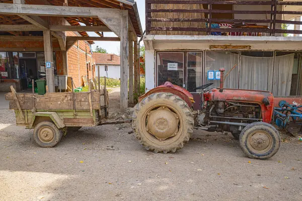 Donja Lakosnica, Razgojna, Jablanica Bölgesi, Sırbistan. 9 Eylül 2024. Sırbistan 'da bir çiftlikte eski traktör ve vagon.