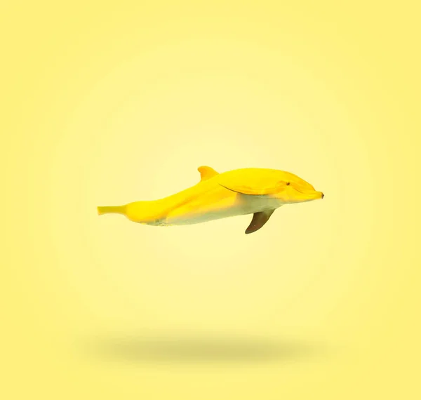 Contemporary art collage. Photo manipulation of a banana and a dolphin. Graphics on a summer yellow background. Modern food concept.
