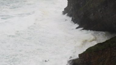 Büyük fırtına dalgalarının uçuruma ve kayalara çarptığı bir deniz manzarası. Erozyon ve deniz tehlikesi kavramı.