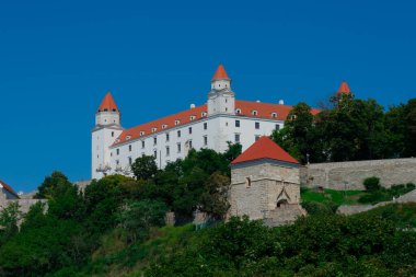 Bratislava, Slovakya. 15 Ağustos 2023. Bratislava Şatosu, Tuna Nehri 'nin üzerindeki küçük Karpatlar' ın kayalık tepesinde dört köşeli kuleleri olan dikdörtgen bina.