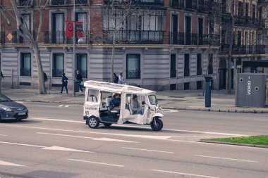 Madrid, İspanya. 15 Şubat 2025. Tuk Tuk ile seyahat eden turistler