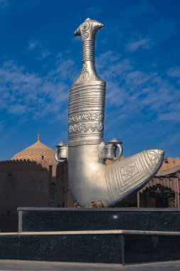Nizwa, Umman. 08 Şubat 2025. Arka planda cami ve pazar olan geleneksel hançer anıtı