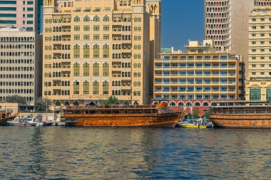Dubai, Birleşik Arap Emirlikleri. 13 Şubat 2025. Geleneksel ahşap darklar Dubai Deresi boyunca kenetlenmiş modern ve klasik binalar arka planda