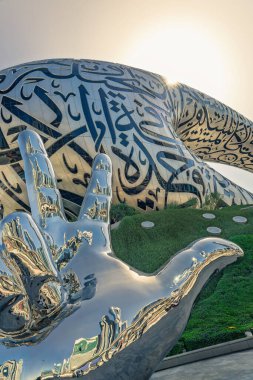 Dubai, Birleşik Arap Emirlikleri. 11 Şubat 2025. Dubais Gelecek Müzesi 'nin önünde üç parmak selamı parlayan krom heykel.