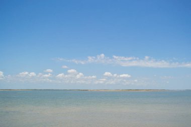 Arkasında küçük bir ada olan okyanus manzarası, beyaz bulutlu mavi gökyüzü, Meksika plajları
