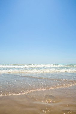 Okyanusta huzur ve sükunet, kumsalda Horizon alçak gelgit ve köpüklü dalgalar.