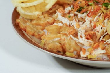 Lezzetli pirinç lapası. Endonezya mutfağından üstü kızarmış tavuk, youtiao, yeşil soğan, kereviz, gevrek soğan ve çıtır kraker ile kaplı.. 