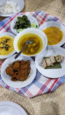 Geleneksel bir Endonezya 'lı' Bedulang 'ziyafeti, dört kişi bacak bacak bacak üstüne atarak yerde oturur, büyük bir tepside servis edilen bir yemeği paylaşır..