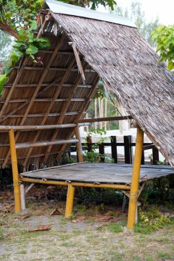 Bambu çerçeveli rahat bir kulübe, örülmüş bambu koltuklar ve kurutulmuş hindistan cevizi yapraklarından (Cocos nucifera) yapılmış bir çatı, dinlenmek için mükemmel bir dinlenme yeri..