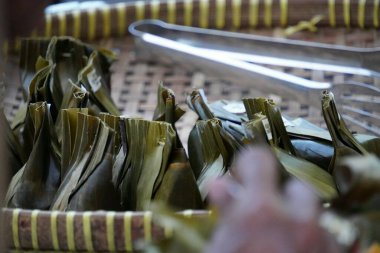 Bambu tepsisinde servis edilen birkaç karang jöle tabağı. Ana malzemeler hindistan cevizi sütü ve baharatla karıştırılmış muz, muz yapraklarına sarılmış ve buharda pişirilmiş..