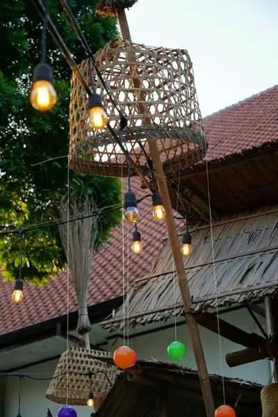 Ters bambu sepetleri, asılı ışıklar ve renkli plastik toplarla süslenmiş bir bambu festival direği..