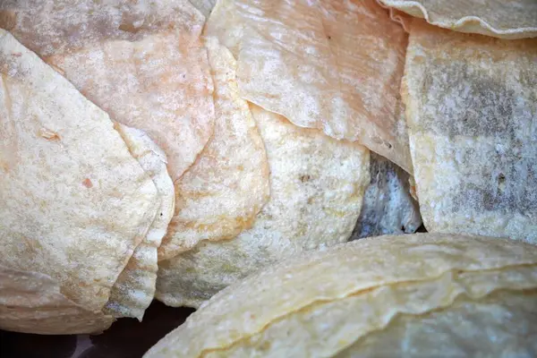 Geleneksel yiyecek: Cassava 'dan yapılmış büyük, ince tapyoka krakerleri (kerupuk lempeng) yığını.