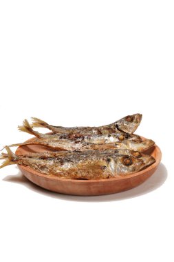 Geleneksel Endonezya mezesi Gereh Keranjang (pindang keranjang) balığı, ahşap bir tabakta servis edilir ve beyaz bir arka planla fotoğraflanır..