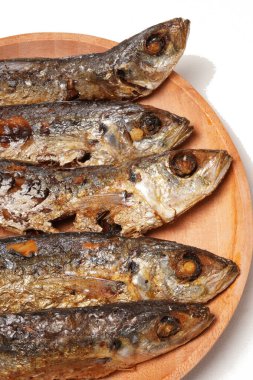 Geleneksel Endonezya mezesi Gereh Keranjang (pindang keranjang) balığı, ahşap bir tabakta servis edilir ve beyaz bir arka planla fotoğraflanır..