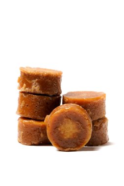 A neatly arranged stack of traditional brown sugar (gula jawa) cylindrical blocks isolated on a clean white background. The rich, caramel color contrasts beautifully with the crisp, minimalist backdrop clipart