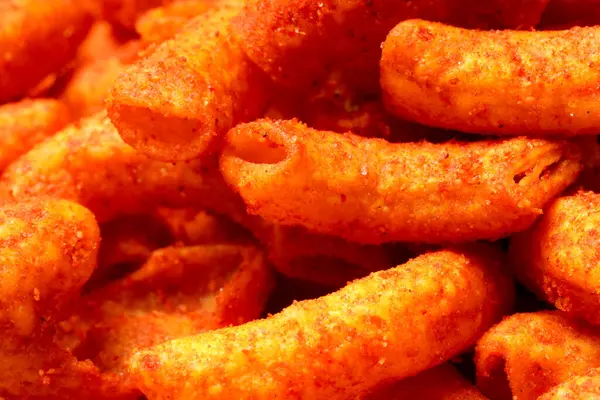 stock image A bowl of crispy, deep-fried macaroni snack coated in spicy red seasoning. Crunchy, savory, and perfect for anytime snacking. Photographed on a white background.