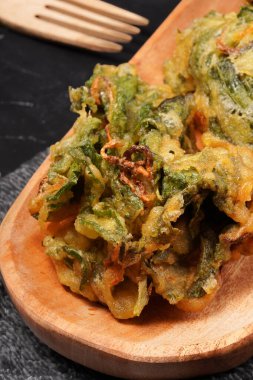 Kızarmış ıspanak, hamurla kaplanmış büyük ıspanak yaprakları ve altın mükemmelliğinde kızartılmış, meze ya da aperatif olarak mükemmel. Karanlık bir arka planda çekilmiş. Amaranthus olarak da bilinir..