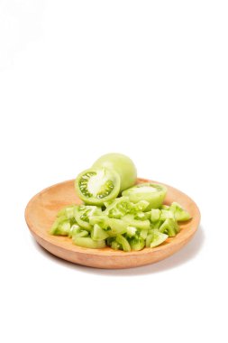 Beyaz arka planda tam ve dilimlenmiş yeşil domatesler (Solanum lycopersicum). Fotoğraf, dilimlerin taze, sulu ve taze dokusunu yakalıyor..