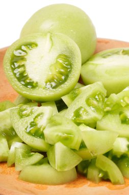 Beyaz arka planda tam ve dilimlenmiş yeşil domatesler (Solanum lycopersicum). Fotoğraf, dilimlerin taze, sulu ve taze dokusunu yakalıyor..