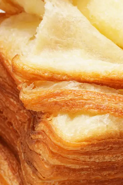 Kore dokuları uzun boylu, çok ince, kare ekmek katmanlı, tereyağlı kruvasan gibi hamurlu. Beyaz arkaplanı olan tahta bir zeminde çekilmiş..