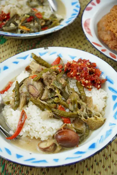 Kremalı hindistan cevizi sütü sebze yahnisi (sayur lodeh), kırmızı biberli sambal, kızarmış tempeh ve sahanda yumurta. Güveç uzun fasulye (Vigna unguiculata) ve genç Jackfruit (Artocarpus heterophyllus) içerir.).