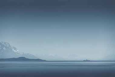Sisli okyanus sabahı ufka doğru yüzen yalnız bir feribotla.