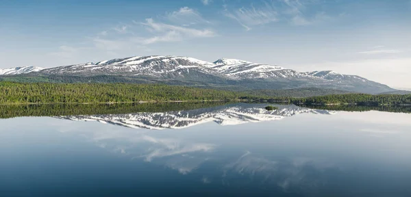 Peaceful mountain landscape with a serene lake reflection in Norway.