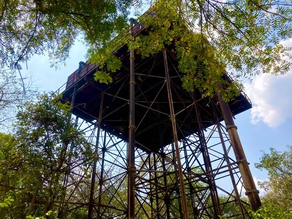 stock image old water tank with pillars of clear blue sky background