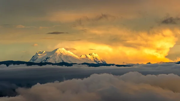 エクアドルアンデス山脈の美しいアンティサナ火山のパノラマビューは 渓谷とキト市の西側を覆う雲と霧の銀行と豪華な夕日によって照らされました — ストック写真