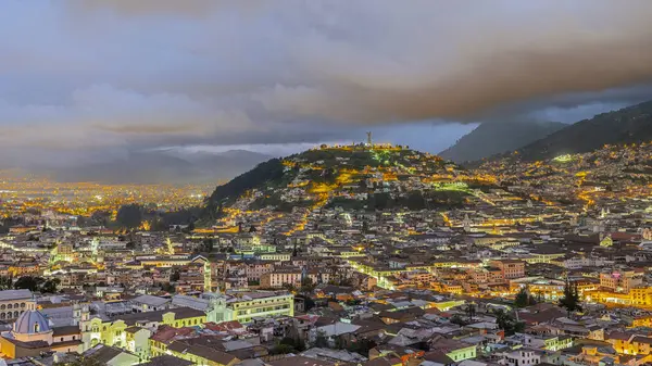 Günbatımında sömürge şehri Quito 'nun panoramik manzarası. Quito Bakiresi 'nin heykeli olan tepe, aynı zamanda Virgen de Legarda olarak da bilinir ya da Meryem Ana, Ekvador başkentinin amblemi, eski sömürge merkezine hükmeder.