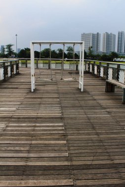 Köprünün ortasında ve göl manzaralı geniş bir bahçede sallan.