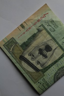 Jakarta, Endonezya 15 Kasım 2022: Beyaz arka planda Suudi Arabistan 'ın el ve cüzdanı 1 riyall banknotunda