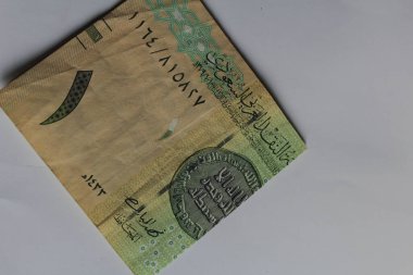 Jakarta, Endonezya 15 Kasım 2022: Beyaz arka planda Suudi Arabistan 'ın el ve cüzdanı 1 riyall banknotunda