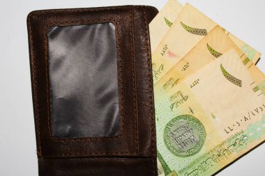 Jakarta, Endonezya 15 Kasım 2022: Beyaz arka planda Suudi Arabistan 'ın el ve cüzdanı 1 riyall banknotunda