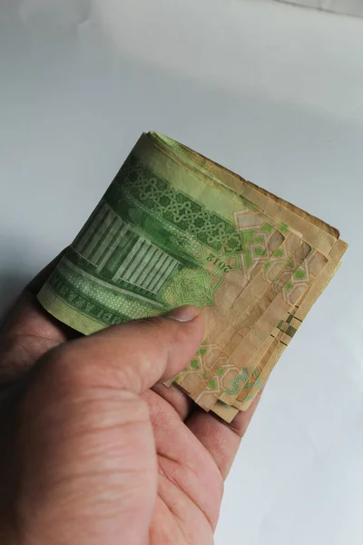 stock image Jakarta, Indonesia 15November 2022: In hand and in wallet 1 riyall banknote of Saudi Arabia on a white background