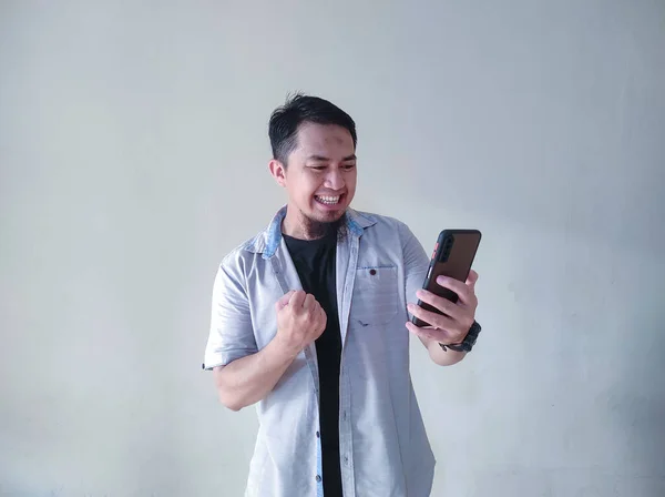 Gammal Asiatisk Man Som Håller Mobiltelefon Knyter Näven Och Visar — Stockfoto