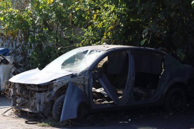 Hurdalıkta hasar görmüş bir araba.