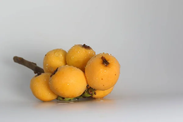 ロカット Eriobtrya Japonica は大きな常緑低木や木で オレンジの果実や葉のために商業的に栽培され ハーブティーを作るために使用されます 熟したビワの実と緑の葉 — ストック写真